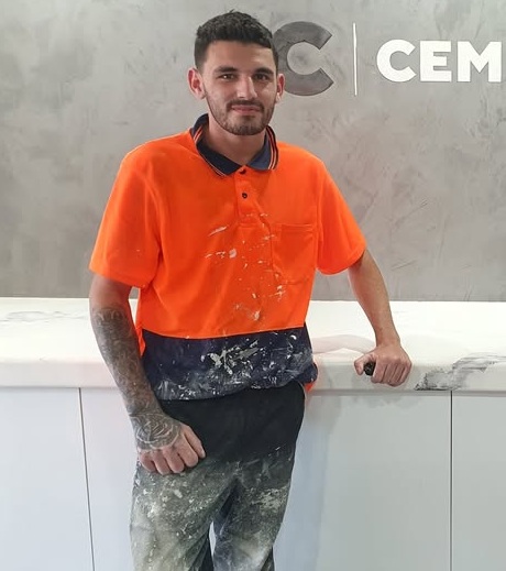 Sanding a micro cement wall during a Cemento DIY training session